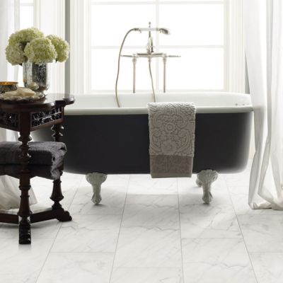 bathroom remodel with marble tile floors and tub near a bright window